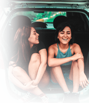 2 femmes assisses dans le coffre d'une voiture